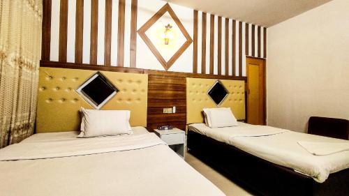 達卡的住宿－White Rose Suites Ltd，一间设有两张床和椅子的房间