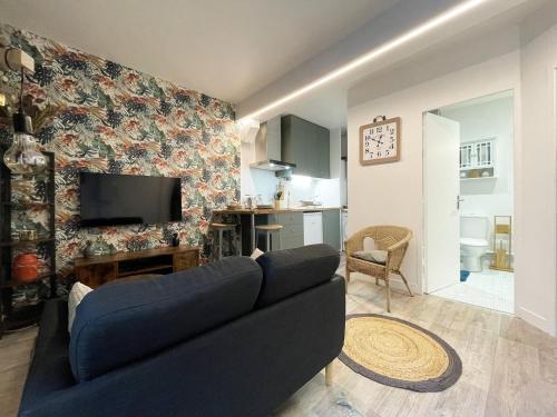 un salon avec un canapé et une télévision dans l'établissement Le Floral - Parking - Self check in, à Chartres