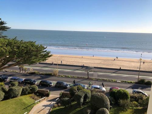 - un parking à côté d'une plage avec des voitures dans l'établissement Splendide et spacieux appartement, face à la mer, à La Baule