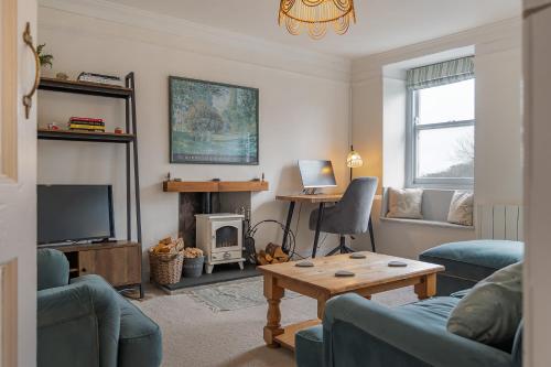 a living room with a couch and a table at Charming Cornish Cottage in the heart of St Agnes in St. Agnes