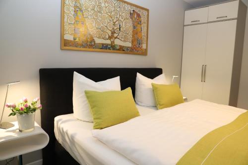 ティースゾーにあるHaus Sterntaucher Ferienwohnung "Sonnenstern"のベッドルーム1室(緑と白の枕が備わるベッド1台付)