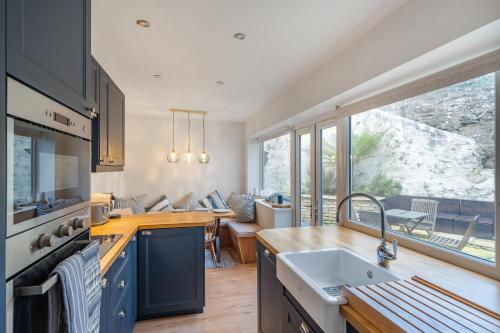 a kitchen with a sink and a large window at Charming Cornish Cottage in the heart of St Agnes in St. Agnes 