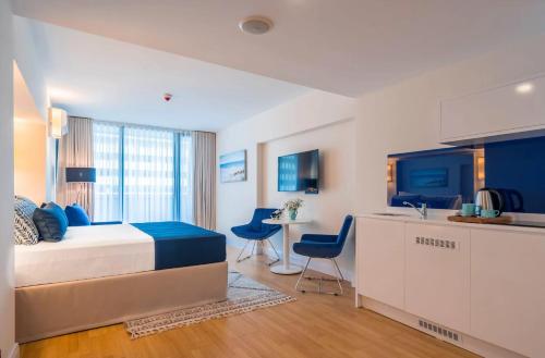 1 dormitorio con cama, escritorio y cocina en Panorama Sea View Central City Batumi & ApartHOTEL, en Batumi