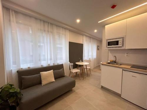 - un salon avec un canapé en face d'une cuisine dans l'établissement Cozy studio in Tetuan - EN 1/9, à Madrid