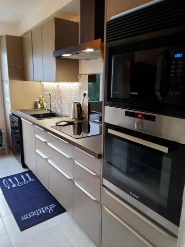 une cuisine avec un micro-ondes et une cuisinière four supérieur dans l'établissement Les goélands, à Perros-Guirec