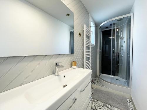 uma casa de banho branca com uma banheira e um lavatório em The Châtelet em Chartres