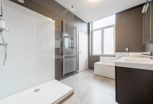 een badkamer met een wastafel, een toilet en een bad bij Smartflats Design - Gaité in Brussel