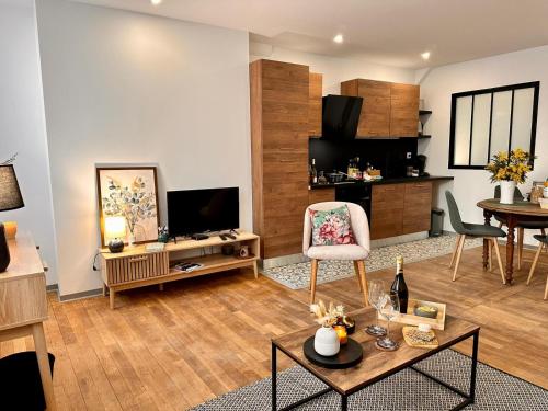 uma sala de estar com um sofá e uma mesa com uma cadeira em Appartement Couteliers-Centre ville-4pers em Moulins