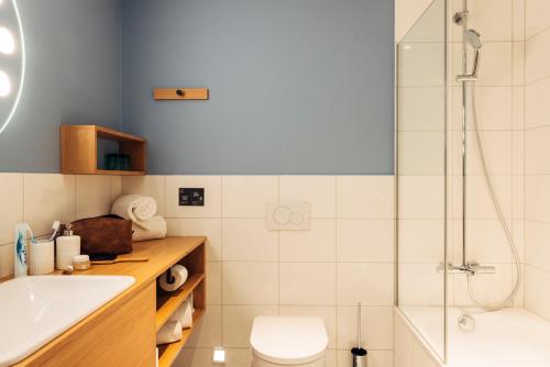 ein Bad mit einer Dusche, einem WC und einem Waschbecken in der Unterkunft harry's home hotel & apartmens in Lienz