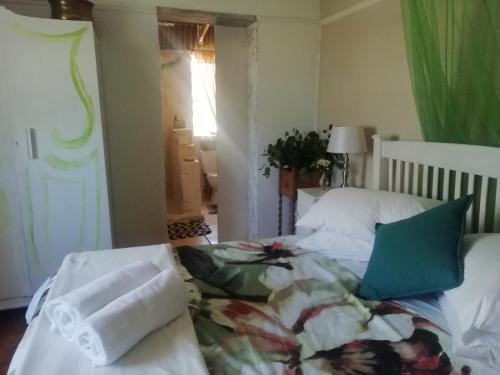 a bedroom with a bed with white sheets and blue pillows at Koringberg siding cottage in Koringberg