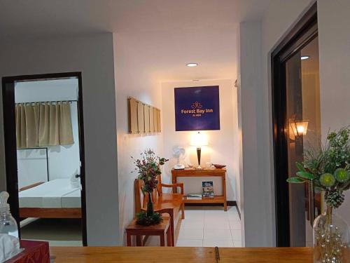 un soggiorno con tavolo e una camera da letto di Forest Bay Inn El Nido a El Nido