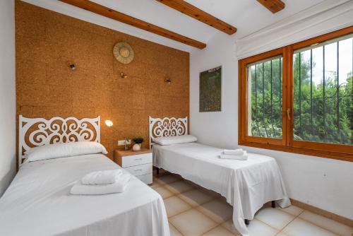 a bedroom with two beds and a window at Villa Escudero - Plusholidays in Calpe