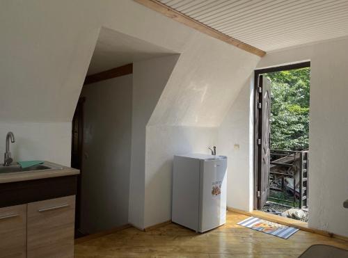 una nevera blanca en una cocina con ventana en Дикий Ліс, en Yaremche