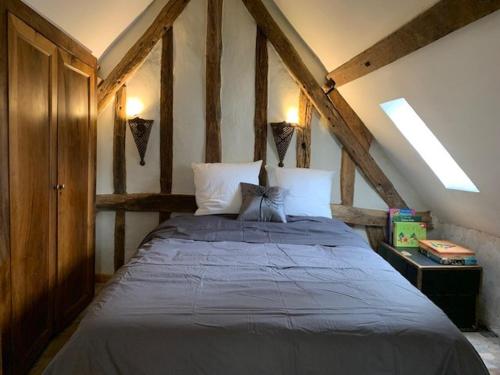 a bedroom with a large bed in an attic at Le tertre Chartrain - Maison de ville in Chartres