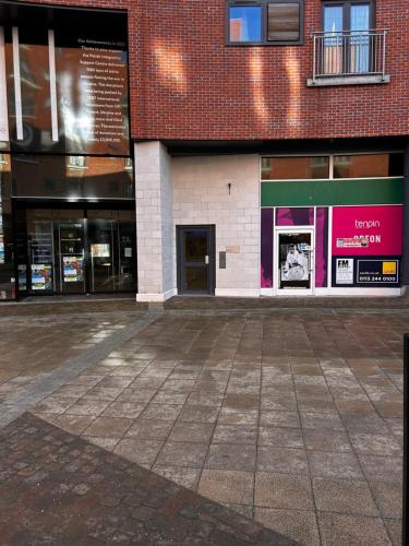 an empty parking lot in front of a building at City Centre apartment. in Wrexham