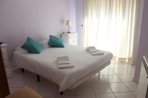 a bedroom with a bed with blue pillows on it at Villa Terra da Eira-Sea view in Lourinhã