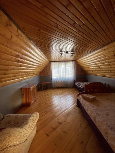 a large room with two beds and a wooden ceiling at Дикий Ліс in Yaremche