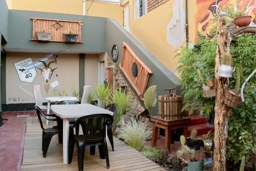 un patio con tavolo, sedie e scala di HOSTEL La Casa de Li - En a Chilecito