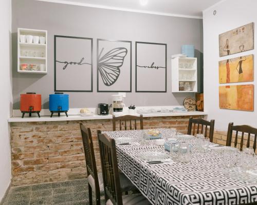 una sala da pranzo con un tavolo con sedie e disegni sul muro di HOSTEL La Casa de Li - En a Chilecito