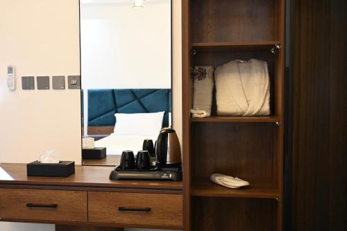 um armário de madeira com um telefone e um espelho em SUN SET HOTEL فندق سن ست em Najran