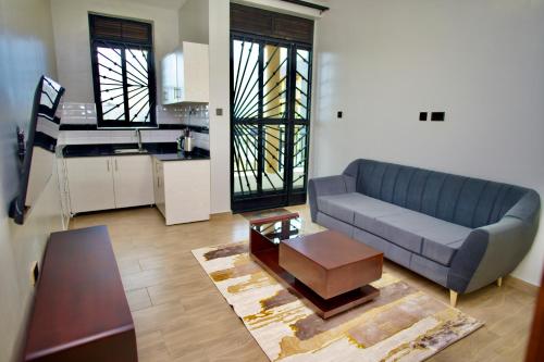 a living room with a blue couch and a kitchen at ATA Lux Apartments in Kira