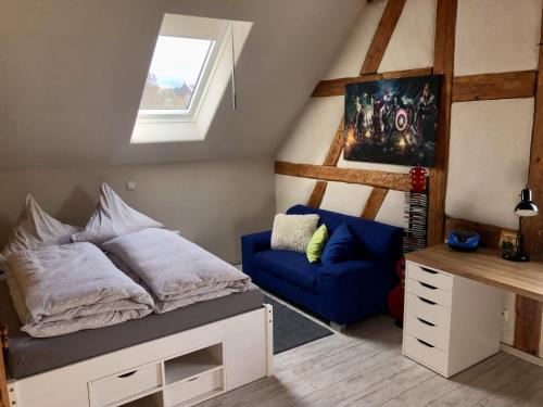 ein Schlafzimmer mit einem Bett und einem blauen Stuhl in der Unterkunft Eschachblick in Zimmern ob Rottweil