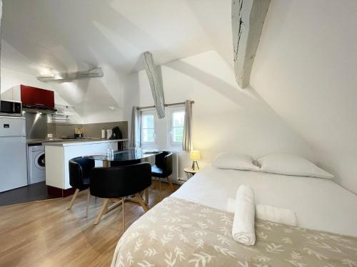 une chambre avec un lit et une table et une cuisine dans l'établissement Le Panorama Chartrain, à Chartres