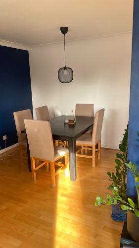 a dining room with a black table and chairs at Best Spot near Stratford in London