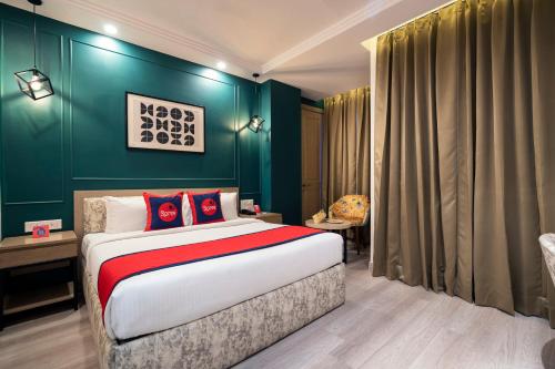 a bedroom with a bed and a green wall at Spree Hotel Kriday Dehradun in Dehradun