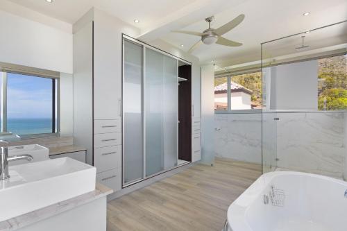 a bathroom with a shower and a sink and a toilet at Atlantic Sky Villa in Gordonʼs Bay