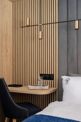 a bedroom with a bed and a table with a chair at Apartamenty Krokusowa Dolina in Kościelisko