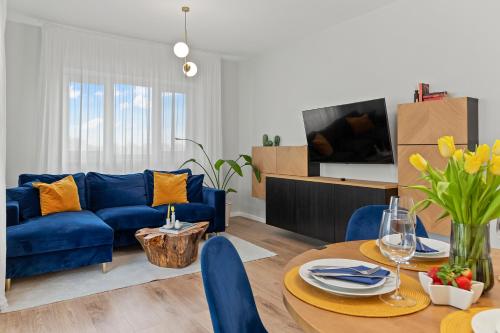 sala de estar con sofá azul y mesa en Mido Park Apartment with Private Parking, en Bucarest