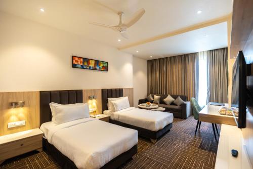 a hotel room with two beds and a couch at Clarks inn Express Ayodhya in Ayodhya