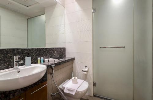 a bathroom with a sink and a toilet and a mirror at Elite LUX Holiday Homes - Bay Square Luxury Studio in Business Bay Dubai in Dubai