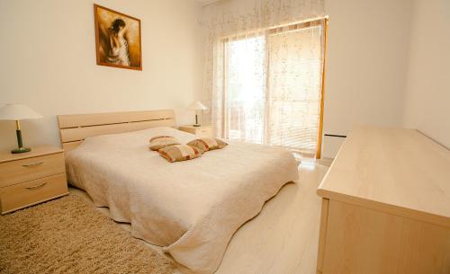 een witte slaapkamer met een bed en een raam bij Papli Apartments in Pärnu