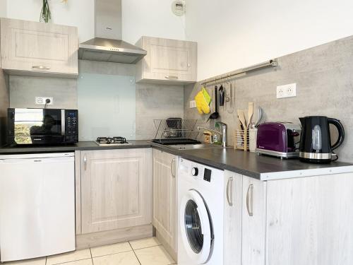une cuisine avec une machine à laver et un lave-linge dans l'établissement Le Matisse, à Mainvilliers
