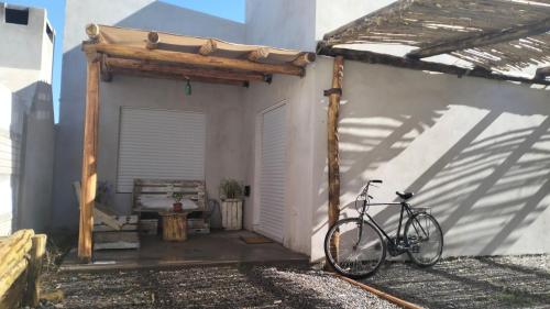 ein Fahrrad, das neben einem weißen Gebäude parkt in der Unterkunft La Rosa dei Venti in Río Colorado