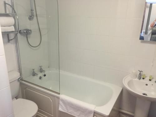 a white bath tub sitting next to a white toilet at The Terrace Lodge Hotel in Yeovil