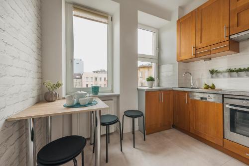 a kitchen with a table and two stools in it at Chmielna Apartments Warsaw Center in Warsaw
