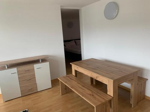 uma mesa de madeira e banco num quarto em Smart Stay Apartment em Feldkirch