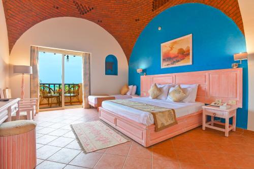 a bedroom with a large bed and a balcony at Dream Lagoon Resort & Aqua Park in Marsa Alam City