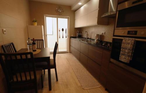 a small kitchen with a table and a refrigerator at Apartamento Carmix in Portimão