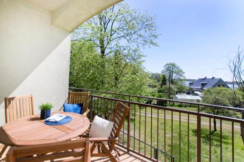 a deck with a table and chairs on a balcony at Apartamenty Delfin in Gdańsk