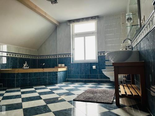 a bathroom with a sink and a toilet and a window at Kapitänshaus an der Warnow mit Sauna in Rostock