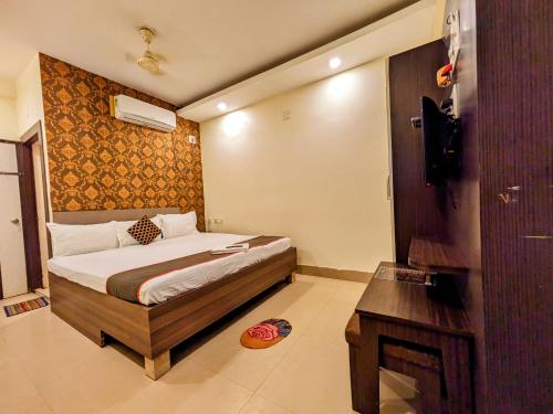 a bedroom with a bed and a desk and a television at HOTEL SUN CITY in Puri