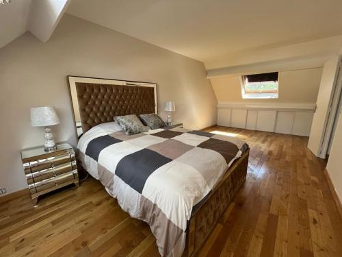um quarto grande com uma cama grande e piso em madeira em Maison de luxe em Saint-Gratien