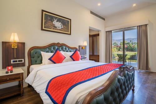 a bedroom with a large bed and a balcony at Spree Resort Sariska in Thāna Ghāzi