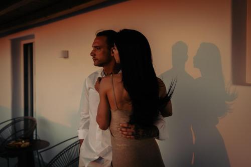 a man and a woman standing in front of a wall at Adama Mykonos Boutique Hotel in Mýkonos City