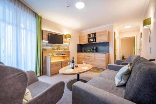 a living room with a couch and a table at Centralhotel Binz in Binz