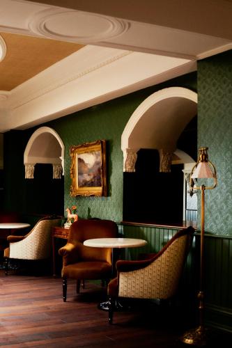 a waiting room with chairs and a table and a ceiling at Slieve Donard in Newcastle